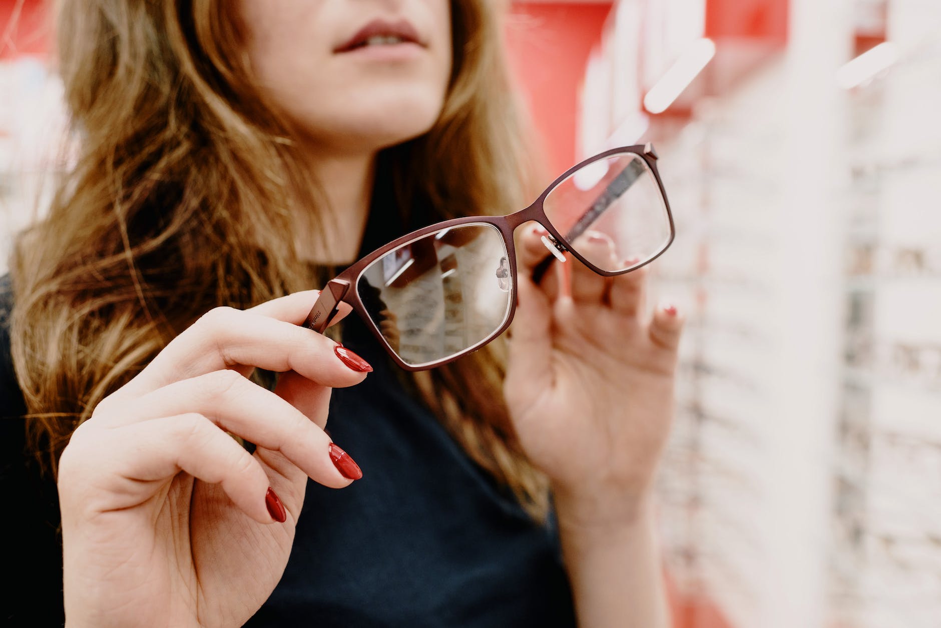 woman choosing glasses in eyewear store