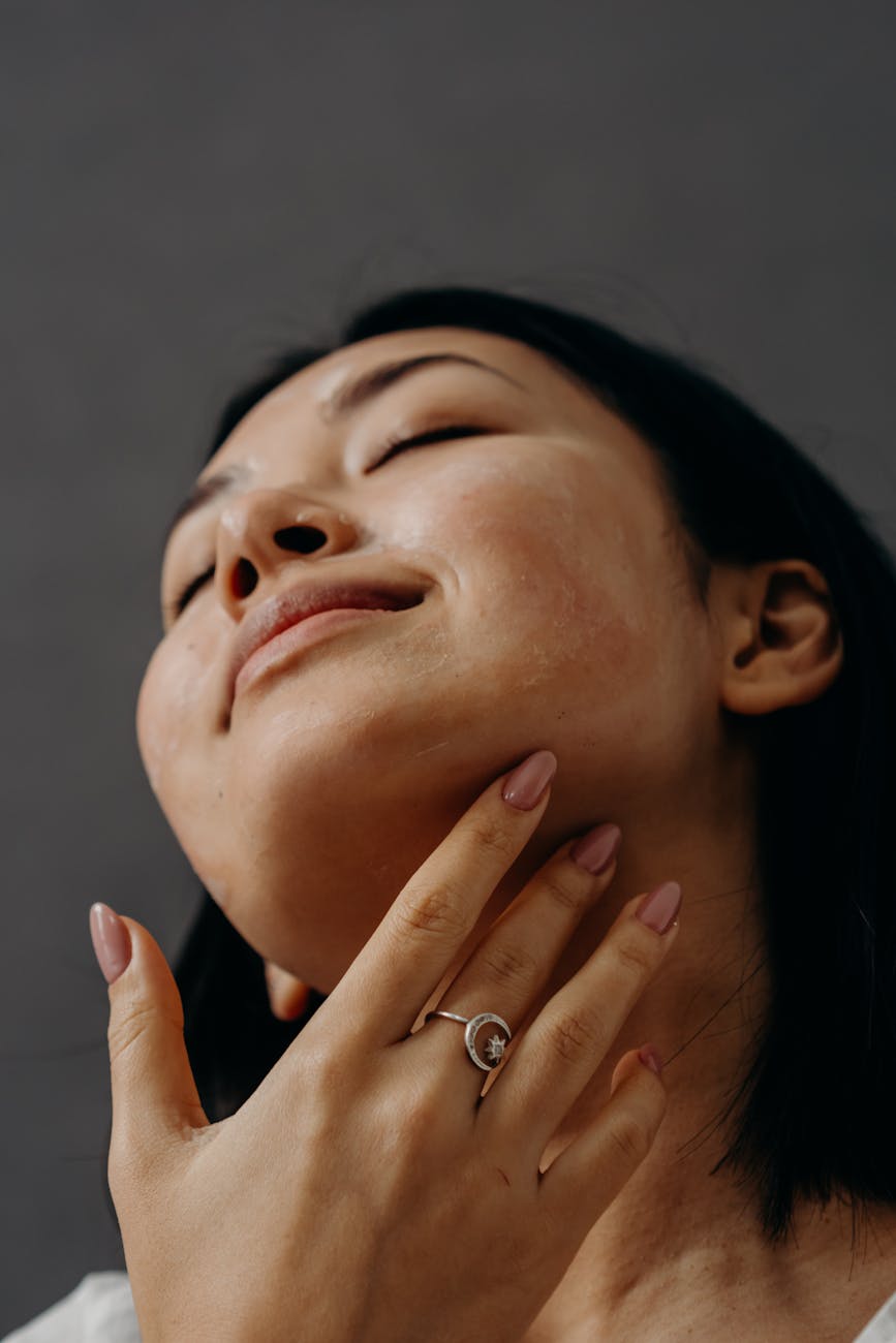 a woman touching her neck with her eyes closed