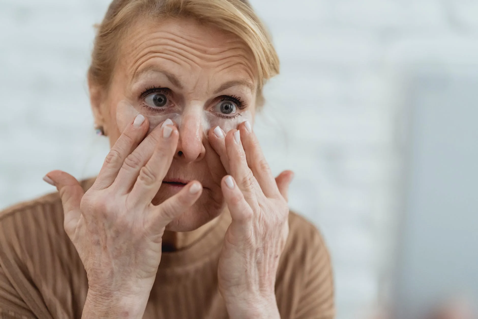 crop senior woman applying hydrating eye patches